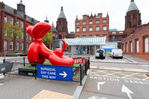 Entrance of Birmingham Children's Hospital with a statue of a red balloon dog